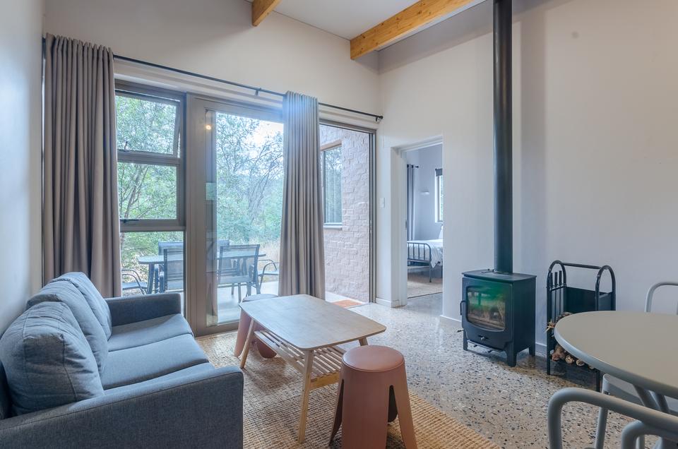 The lounge of a VIP cottage, with a fireplace and doors to the deck.