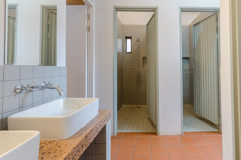 A dorm bathroom with separate shower and toilet cubicles.