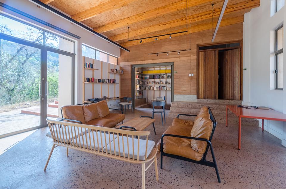 The lounge at the school, with leather chairs and bookshelves.