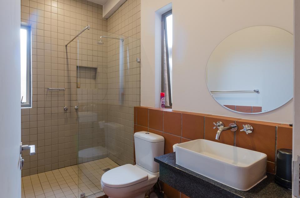 A single room bathroom with a glass shower.