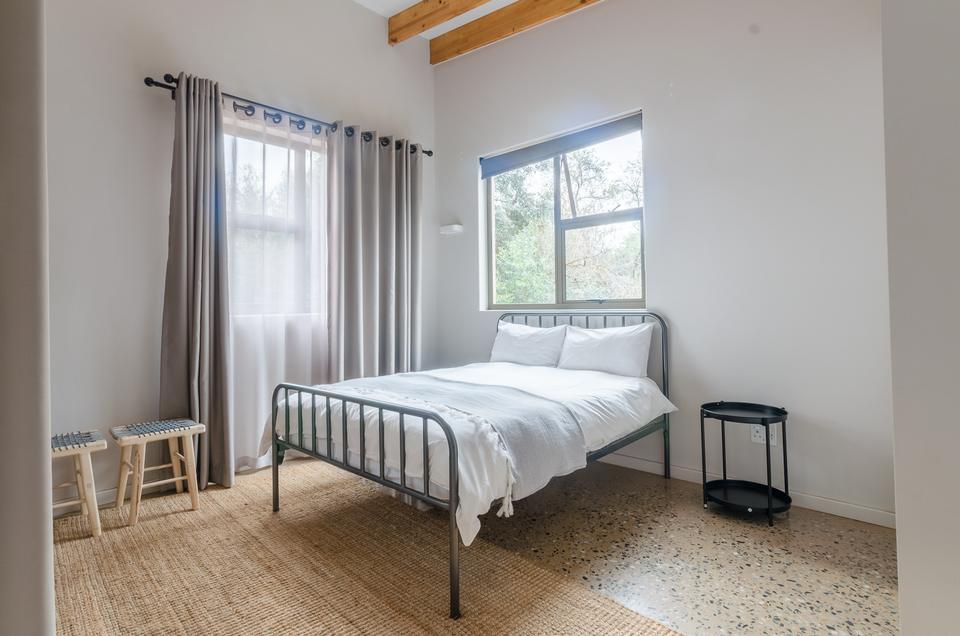 A second single room with a double bed by the window.