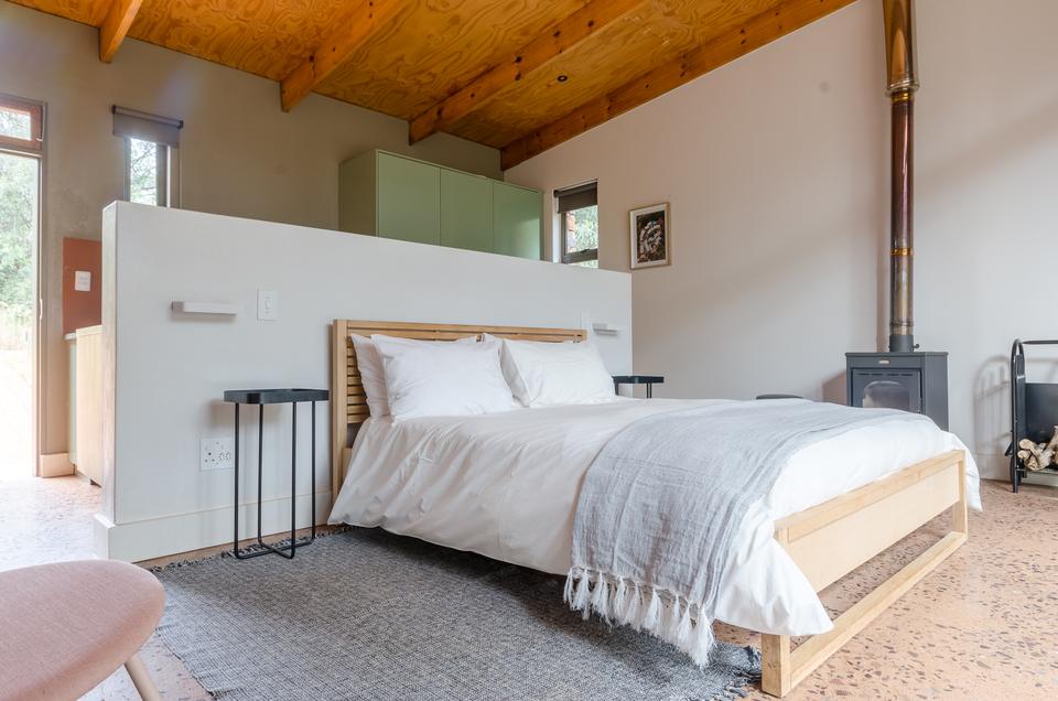 A VIP room with a double bed and a wood stove.